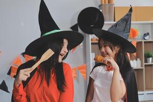 friendship, holiday and people concept - group of happy smiling friends in halloween costumes of vampire, devil, witch and cheetah at home party photo