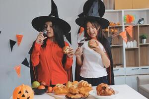 friendship, holiday and people concept - group of happy smiling friends in halloween costumes of vampire, devil, witch and cheetah at home party photo