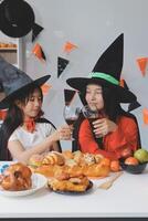 friendship, holiday and people concept - group of happy smiling friends in halloween costumes of vampire, devil, witch and cheetah at home party photo