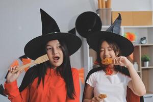 friendship, holiday and people concept - group of happy smiling friends in halloween costumes of vampire, devil, witch and cheetah at home party photo