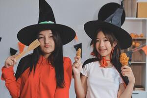 friendship, holiday and people concept - group of happy smiling friends in halloween costumes of vampire, devil, witch and cheetah at home party photo