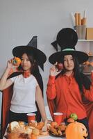 friendship, holiday and people concept - group of happy smiling friends in halloween costumes of vampire, devil, witch and cheetah at home party photo