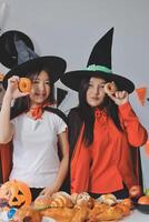 friendship, holiday and people concept - group of happy smiling friends in halloween costumes of vampire, devil, witch and cheetah at home party photo