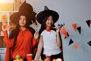 friendship, holiday and people concept - group of happy smiling friends in halloween costumes of vampire, devil, witch and cheetah at home party photo