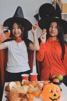 friendship, holiday and people concept - group of happy smiling friends in halloween costumes of vampire, devil, witch and cheetah at home party photo