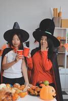 friendship, holiday and people concept - group of happy smiling friends in halloween costumes of vampire, devil, witch and cheetah at home party photo