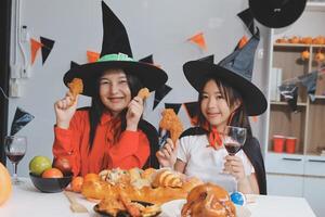 friendship, holiday and people concept - group of happy smiling friends in halloween costumes of vampire, devil, witch and cheetah at home party photo