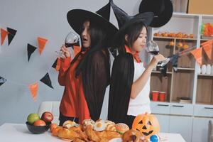 friendship, holiday and people concept - group of happy smiling friends in halloween costumes of vampire, devil, witch and cheetah at home party photo