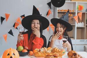 friendship, holiday and people concept - group of happy smiling friends in halloween costumes of vampire, devil, witch and cheetah at home party photo