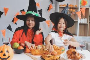 friendship, holiday and people concept - group of happy smiling friends in halloween costumes of vampire, devil, witch and cheetah at home party photo