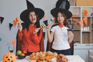 friendship, holiday and people concept - group of happy smiling friends in halloween costumes of vampire, devil, witch and cheetah at home party photo