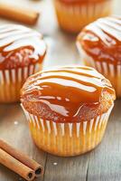 Delicious salted caramel cupcakes with drizzled sauce and baking ingredients on a rustic wooden table photo