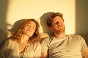 Couple relaxing on a sofa in a minimalistic living room enjoying the evening light after a long workday photo
