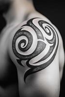 A close-up of a tribal tattoo on the shoulder, featuring intricate swirling patterns and sharp lines. photo