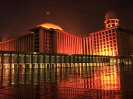 Istiqlal Mosque, Jakarta with golden lights on in the evening photo