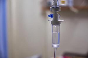 Close-up of slow iv fluid intravenous drip saline with blurred background in a hospital room, medical concept with copy space photo