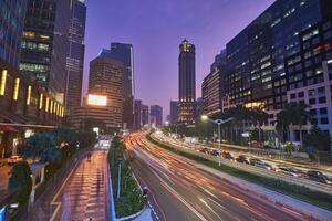 Traffic conditions in main road of Jakarta business center with office buildings photo