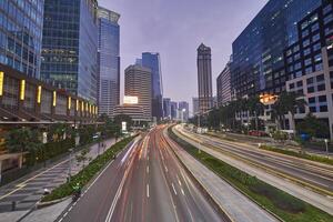 Traffic conditions in main road of Jakarta business center with office buildings photo