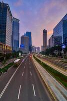 Traffic conditions in main road of Jakarta business center with office buildings photo