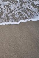Sandy beach with small waves, an abstract background photo