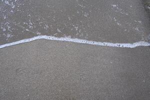 Sandy beach with small waves, an abstract background photo