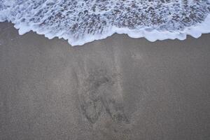 Sandy beach with small waves, an abstract background photo