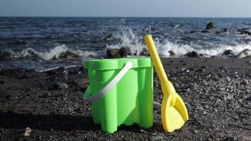 A bucket and shovel on the beach with the ocean in the background video