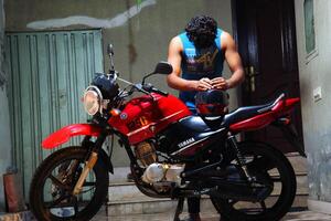 a man is sitting on a motorcycle in DHA Lahore on September 21, 2024 photo
