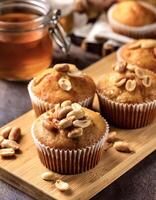Peanut Muffins. Fluffy peanut muffins with a drizzle of honey, presented on a wooden board photo