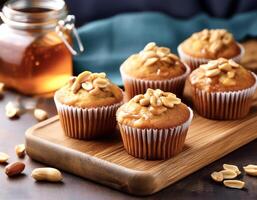 Peanut Muffins. Fluffy peanut muffins with a drizzle of honey, presented on a wooden board photo