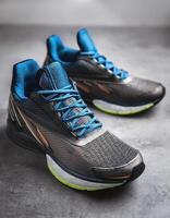 A pair of insulated running shoes on a concrete surface. Sports Shoes photo