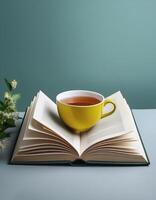 An open book with a cup of tea beside it isolated on minimalist background photo
