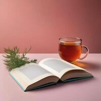 An open book with a cup of tea beside it isolated on minimalist background photo