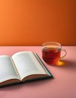 An open book with a cup of tea beside it isolated on minimalist background photo