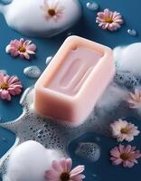 Bar soap is kept on a minimalist background with flowers surrounding it and foam photo