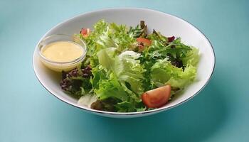 Fresh salad in a white bowl with dressing on the side isolated on a minimalist background photo