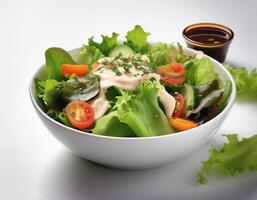 Fresh salad in a white bowl with dressing on the side isolated on a minimalist background photo