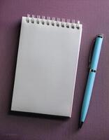 Pen and notebook isolated on minimalist background photo