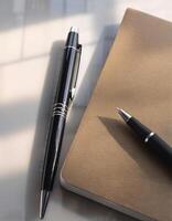 Pen and notebook placed on a clean table photo