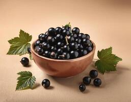 Black currants in a bowl, surrounded on a beige background photo