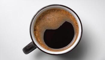A cup of black coffee with froth on top, placed on a white surface photo