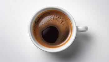 A cup of black coffee with froth on top, placed on a white surface photo