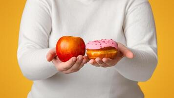 Difficult Choice. Unrecognizable Overweight Girl Holding Donut And Apple In Hands, Comparing Healthy And Unhealthy Food, Selective Focus, Crop photo