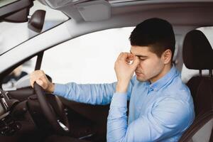 Depressed Man Sitting In Driver's Seat Of New Too Expensive Car, Thinking Of Money Problems In Auto Dealership Store photo