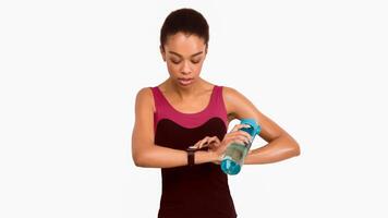 Black Woman Using Fitness Tracker Watch During Workout Standing Over White Studio Background. Panorama, Isolated photo