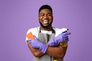 Joyful Black Man With Household Tools In Hands Ready To Clean, Posing Over Pink Background, Copy Space photo