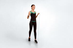 Happy African American Girl Exercising With Jump Skip Rope Over Yellow Studio Background. Full Length, Free Space For Text photo