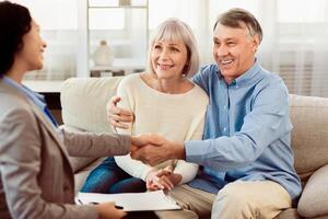 Real Deal. Real estate agent giving handshake to smiling elderly couple after successful agreement, free space photo