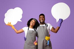 Cheerful Black Janitors Couple Holding Empty Speech Bubbles In Hands While Posing Over Pink Background In Studio, Copy Space photo