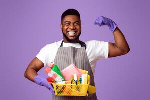 Mister Muscle. Handsome Black Man With Lots Of Detergents In Hands Showing Biceps, Posing Over Pink Studio Background With Copy Space photo